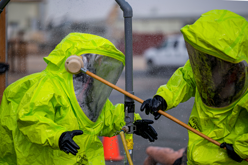 Physical and chemical decontamination of personnel in protective suits.