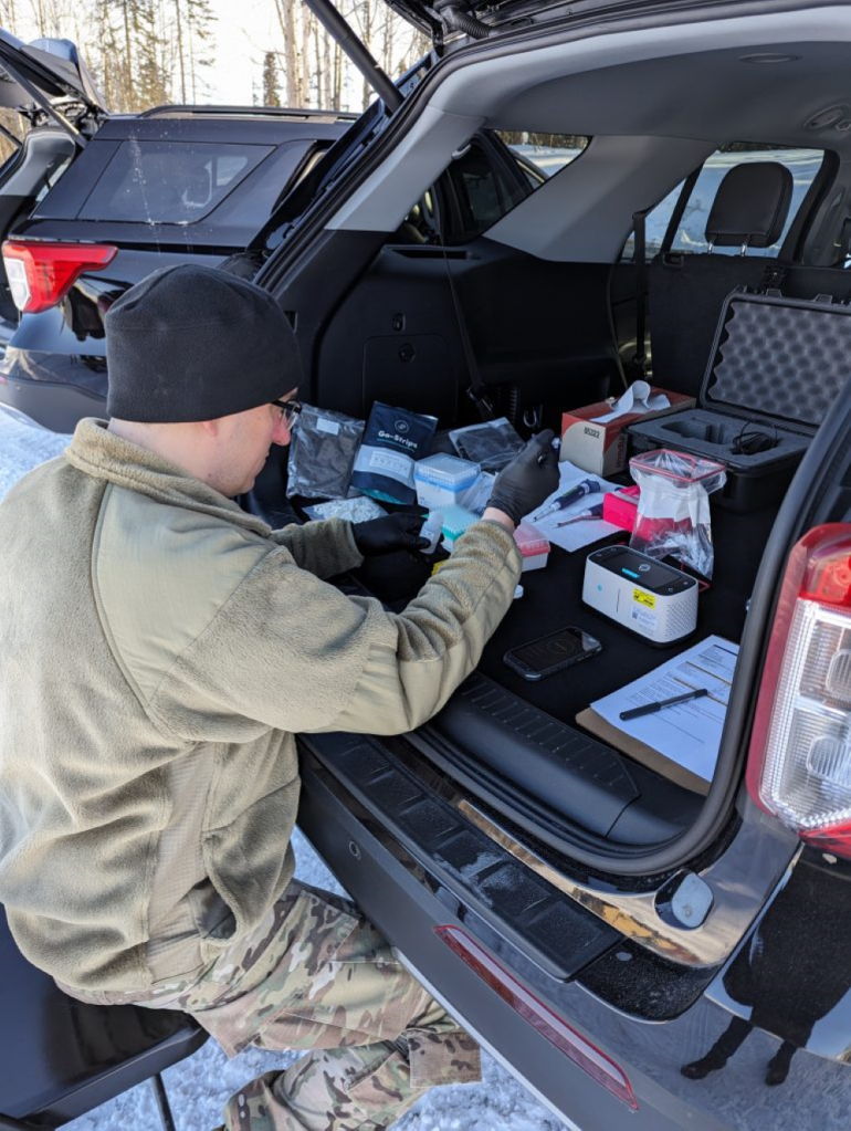 Army Captain conducting biological testing in the back of a SUV.