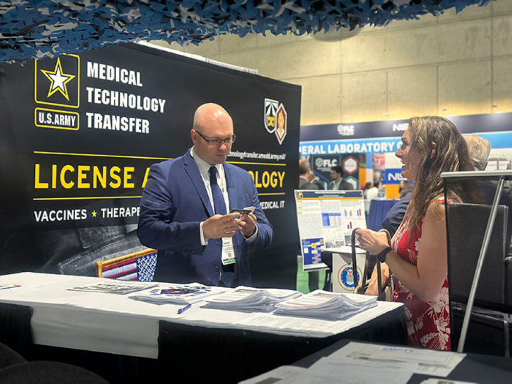 Two conference attendees having a discussion at an exhibiting booth.