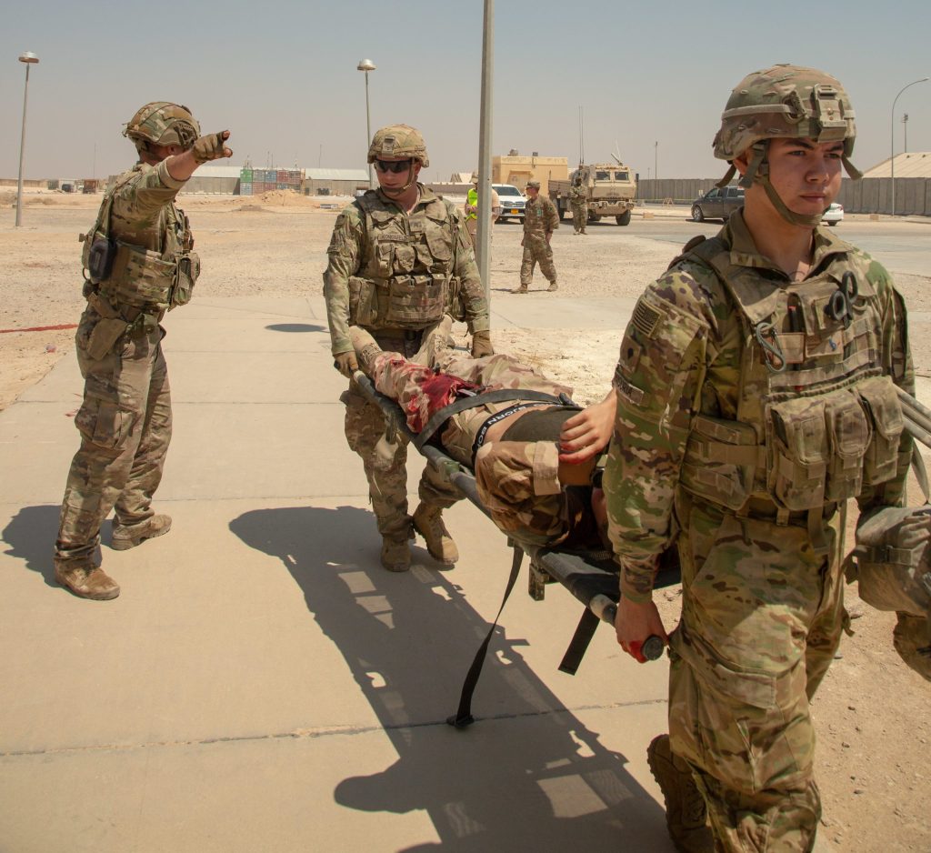 Soldiers carry a mock wounded comrade on a litter during training.