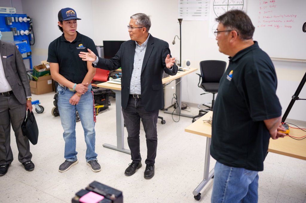 Sandia National Laboratories Senior Scientist Stan Atcitty. center, speaks during a visit to Navajo Technical University