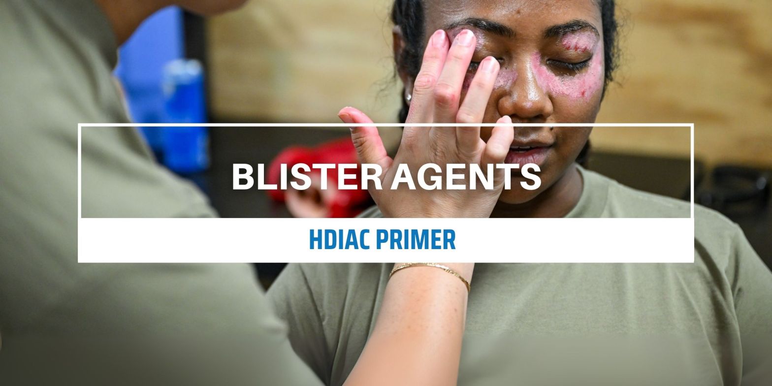 A USAF medic applies moulage around the eyes of another medic ahead of a simulated blister agent attack exercise