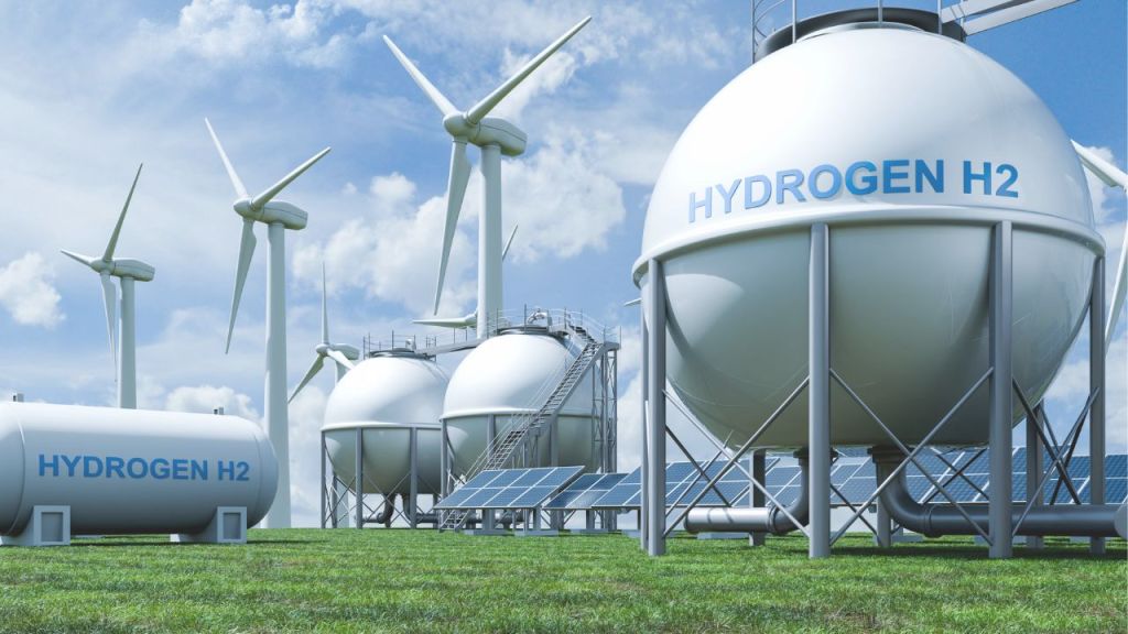 large, white hydrogen gas tanks with windmills and solar panels in the background