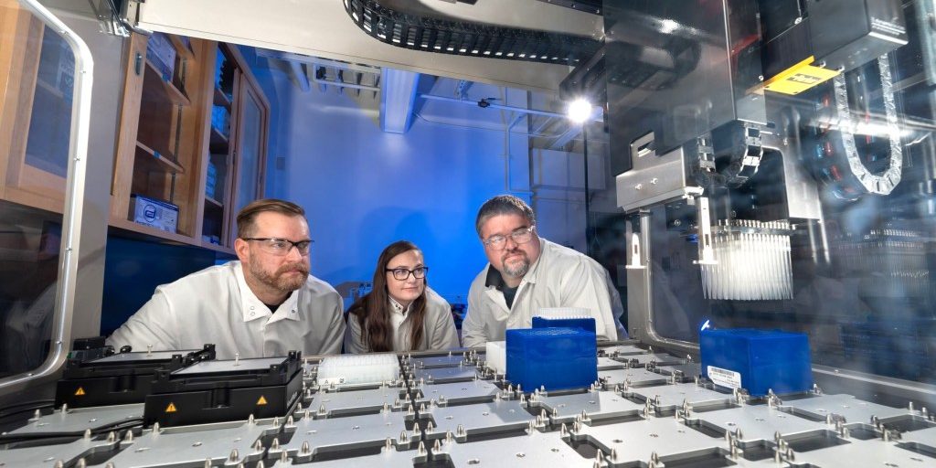 From left: chemists Brian Mayer and Katelyn Mason and biologist Todd Corzett observe the operation of the robot that independently executes the acetylchlolinersterase assays the team uses to assess Novichok inhibition and to discover new oxime antidotes for Novichok poisoning. (Photo: Blaise Douros/LLNL)