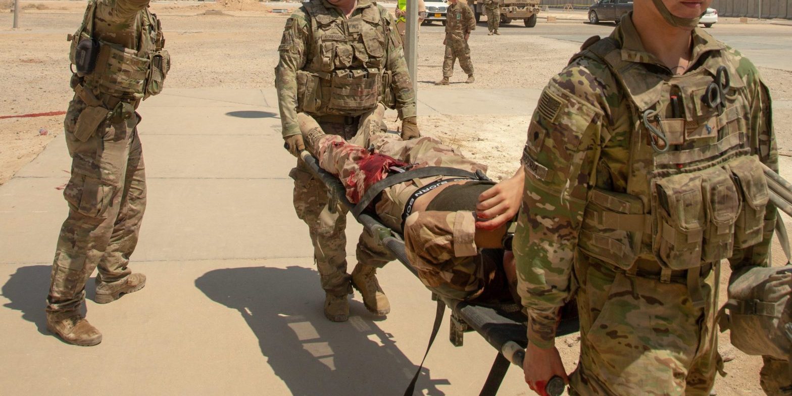 Soldiers carry a mock wounded comrade on a litter during training.