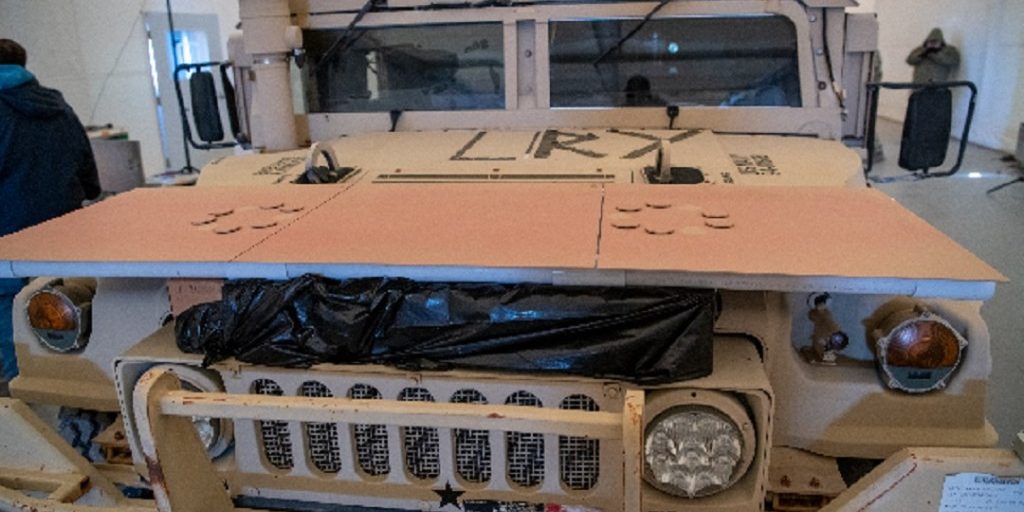 A military vehicle undergoes testing and demonstration of a protective overcoating using sample panels during a demonstration in 2022 (U.S. Army photo by Dugway Proving Ground Public Affairs).