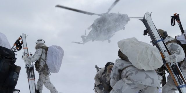 U.S. Army Green Berets with 10th Special Forces Group (Airborne) and Finnish Army special operations soldiers with Utti Jaeger Regiment posture on a helicopter landing zone in Lapland, Finland, March 12, 2023. The Utti Jaeger Regiment hosted Exercise Talvikotka 23 from March 12-16, 2023, inside the Arctic Circle to enhance and exchange winter warfare tactics and techniques (Staff Sgt. Anthony Bryant, U.S. Army).