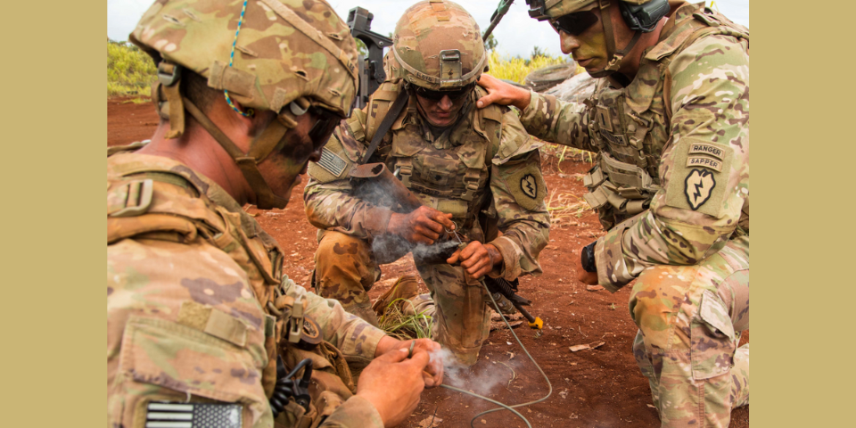 Three military personnel initiate a detonation process.