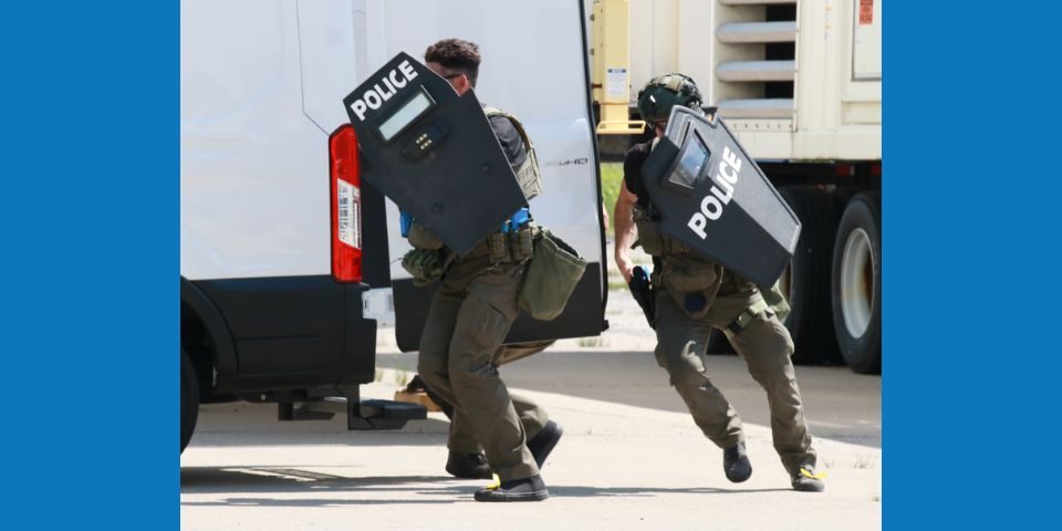 Two law enforcement agents training with shields.