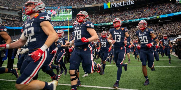 The U.S. Naval Academy football team runs onto the field during the annual Army-Navy football game held at MetLife Stadium in East Rutherford, New Jersey, December 11. Navy student athletes are part of an ongoing concussion study being conducted by the joint NCAA-DoD CARE Consortium (photo by Navy Chief Petty Officer Diana Quinlan, Navy Recruiting Command).