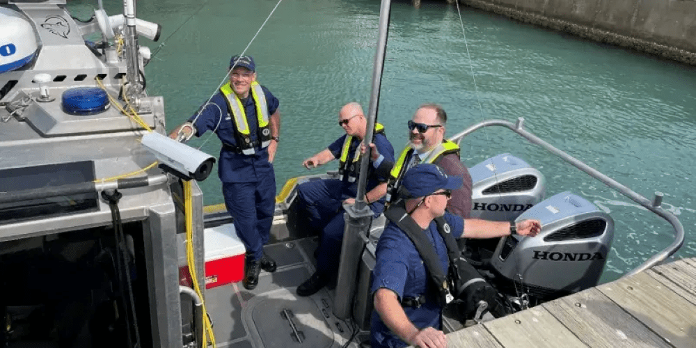 Three Department of Homeland Security personnel standing on a naval craft.