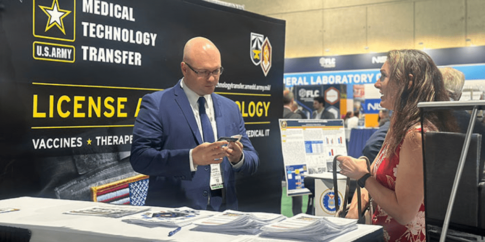 Two conference attendees having a discussion at an exhibiting booth.