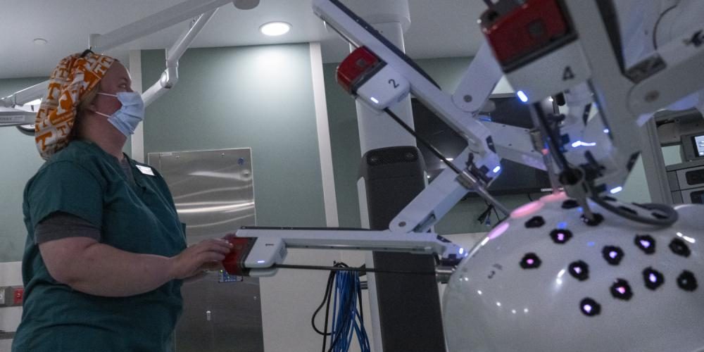 A medical staffer slides in a new tool sleeve into the 96th Medical Group's new surgical robot on November 1 at Eglin Air Force Base, FL. The quad-armed robot completed its first procedure on November 2. The robot will be used for most general and even more complex procedures in the future (U.S. Air Force photo/Samuel King Jr.).