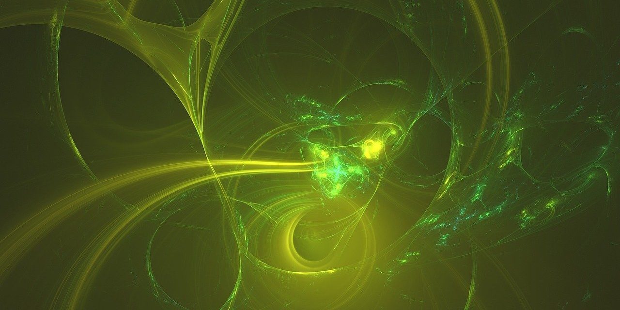 The image is of a green and yellow cloud or particles swirling on a black background.