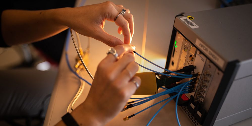  A firmware developer works with a toolbox-sized prototype for a software-defined system called Multi-Mission Radio Frequency Architecture (Sandia National Laboratories).